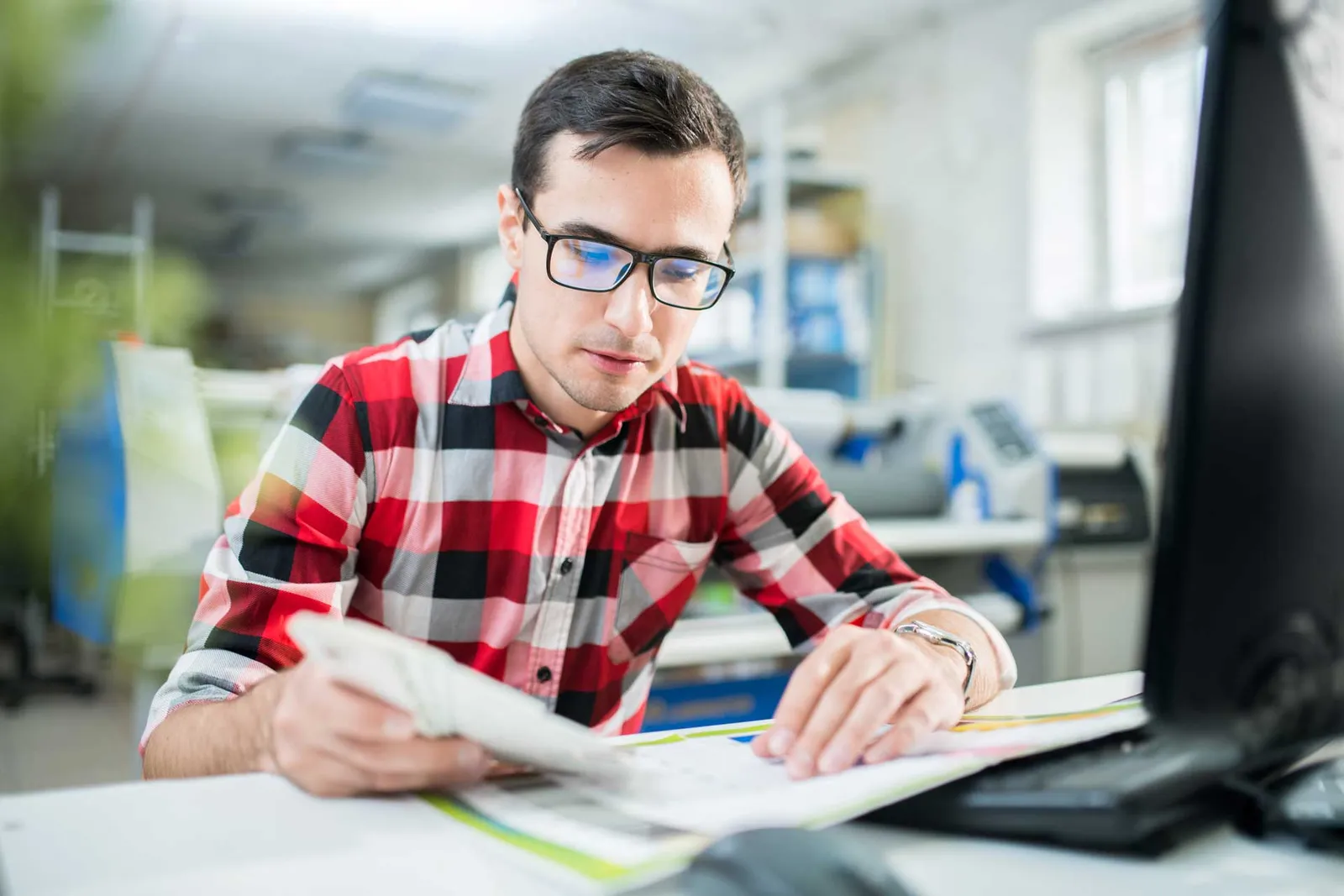 concentrated designer examining quality of print